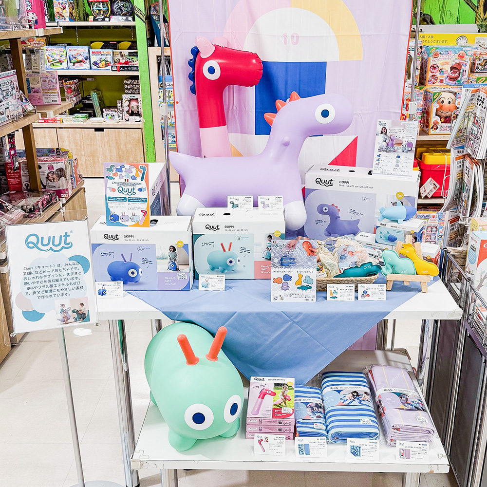 鶴屋百貨店のQuutフェアの様子です。プレイタオルが吊るされて展示されています。乗用玩具もテーブルの上で展示販売されています。